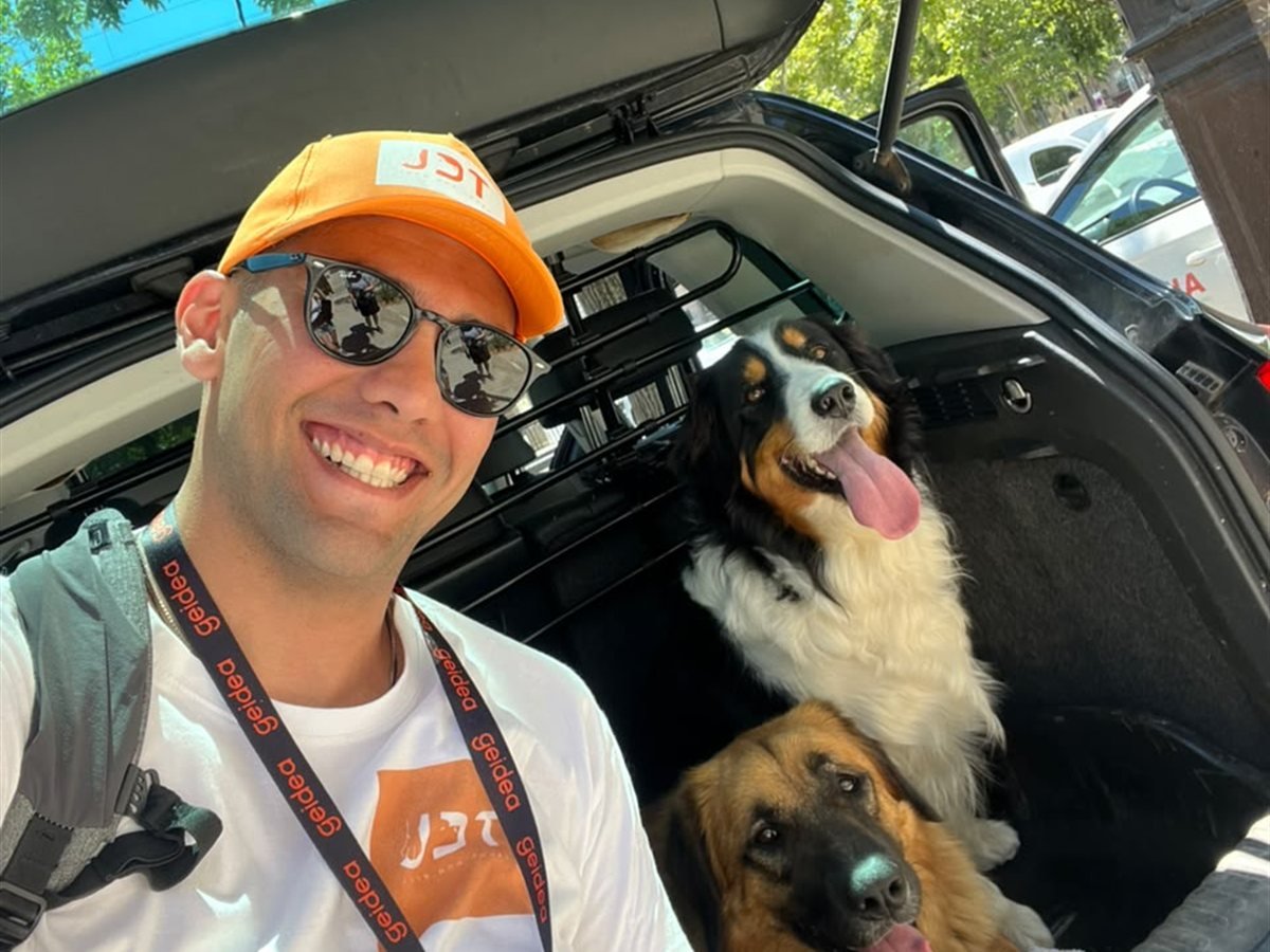Joon Dog Tours guide with two dogs beside the tour vehicle in Paris